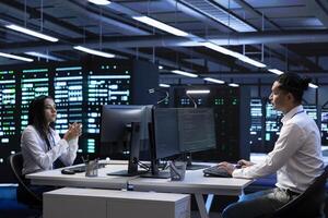 Technicians in data center workspace running system diagnostic tests and error checking utilities to fix problems. Employee looking for network issues affecting rigs performance and connectivity photo