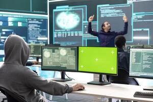 Professional team of governmental hackers conducting cyber surveillance, looks at isolated copy space screen. Expert examines cybersecurity measures and online security in high tech agency. photo