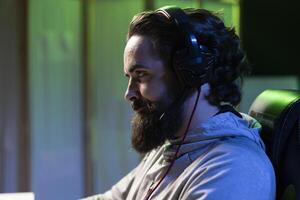 Man discussing with friends online while playing singleplayer videogame, having fun finishing missions together. Close up of gamer chatting with teammates in game using headphones mic photo