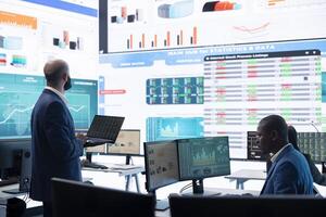Teammates and manager assembling in a big data room to go over their results, examining graphic representations with feedback from shareholders investors. Exchanging perspectives. photo