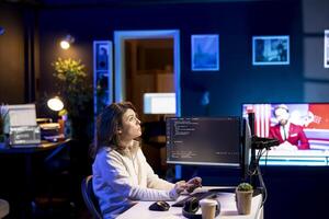 Developer in neon lit apartment implement security measures using augmented reality tech, protecting data. System administrator working from home, debugging code, looking at AR visualization photo