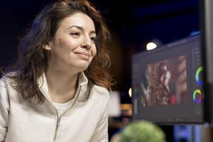 Happy videographer using professional software to create visual effects for projects. Smiling expert using post production techniques to edit raw clips footage in home office photo