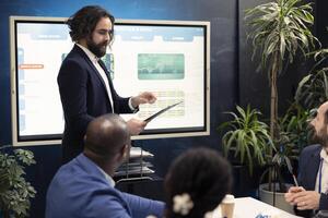 Business peers conducting an informational session to share updates on projects and arrangements, evaluating the latest economic projections on paperwork in order to guarantee progress. photo