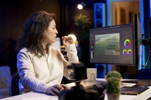 Professional editor analyzing film montage before editing color grading and lighting in creative office. Post production studio employee working with raw footage, improving quality photo