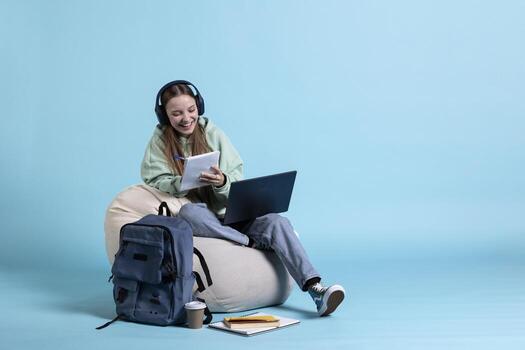 Happy woman using to memorize information for school exam, isolated over studio background. Cheerful student holding notebook, remembering and practicing before university assessment photo
