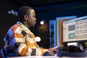 Research specialist reviewing financial elements and expenses to create strategic report for revenue growth. African american financier examines capital funds balance, remote work. photo