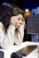 Stressed programmer rubbing temples, trying to fix vulnerabilities in software systems, suffering headache. Tired IT expert feeling pain from fatigue, using PC to patch security exposures photo