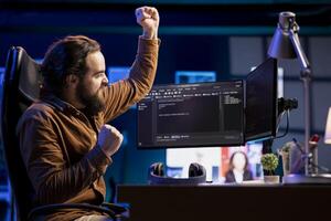 Ecstatic cybersecurity specialist celebrating after finding security vulnerabilities and preventing malware infections. Excited programmer delighted about preventing cyberattacks photo