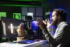 Gamer unable to understand what happened after being defeated by opponents while playing esports tournament. Surprised player feeling shocked after losing while competing in multiplayer videogame photo