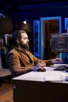 System administrator securing company servers from DDoS attacks to avoid unwanted failures. IT professional in apartment writing code to build firewalls protecting data from threats photo