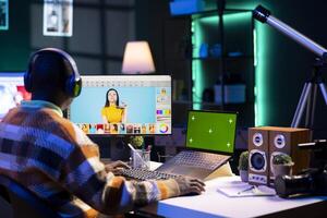 Male graphic artist using essential digital tools next to isolated mockup screen, professional design work showcasing modern setup at home. Designer showing advanced photo editing skills.