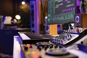 Empty home studio used to create music with electronic console and devices, pre amp knobs and soundboard with control panel. Space equipped with amplifier and tools, mixing and mastering. photo