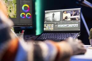 editor working on creative software to create a film montage, using color correction wheel and adding visual effects. Male creator editing gradient for movie post production, white balance. photo