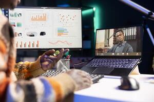 African american male freelancer attends virtual meeting call with clients on laptop, working at home and sharing insight on income statistics. Person looking at screen and listening to call. photo