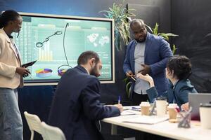 Financial team working on ways to obtain funds from shareholders, creating an interactive presentation to explain resources needed. Accounting group following market trends and infographics. photo
