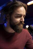 Songwriter composing new music and singing on microphone, playing piano keyboard and recording song for mixing and mastering session. Artist using audio equipment in home studio. Close up. photo