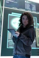 Female hacker breaching network security with advanced techniques, cyber defense in action. IT expert examines important hybrid war intelligence on a big screen, gaining access. photo