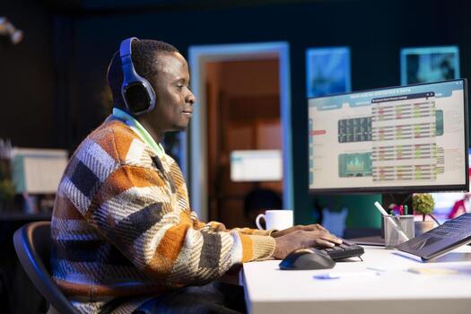 African american specialist closing the monthly revenue balance, working remotely while he listens to music on accounting analysis. Advisor managing expenses and insurances before investing. photo