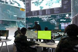 Private monitors national guard activity with federal CCTV radar system, working with a green screen layout on pc in control center. IT reconnaissance operator tracking ships on world map. photo