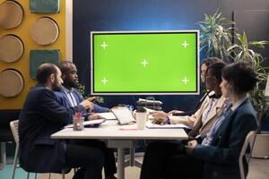 Marketing experts meeting in a boardroom with isolated TV layout, working to improve the enterprise image and social media presence. Business specialists conducting multiple analysis. photo