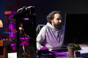 Man at home playing singleplayer videogame shooting enemies to finish level. Pro gamer destroying opponent team members in science fiction game using gaming mouse, having fun photo