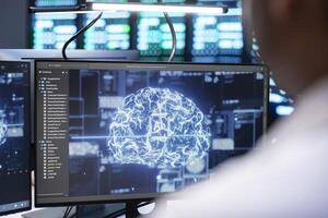 Engineer using AI tech on computer to do checkup in server farm providing storage. IT expert using PC to enable artificial intelligence to process datasets for training and inference photo