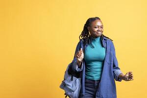 Happy african american person having fun, dancing on rhythm, enjoying leisure time. Cheerful BIPOC woman entertaining herself doing funky movements on music, studio background photo