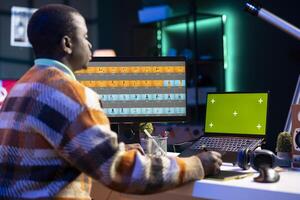 Remote graphic designer using advanced editing software and isolated display to retouch images, embodying the creativity and technological power of the digital art industry. Retouching work. photo