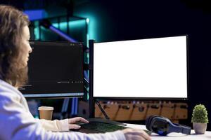 Freelancing admin using isolated screen computer monitors to filter malicious traffic from cybercriminals attempting to corrupt company data. IT specialist in apartment working on mockup desktop PC photo