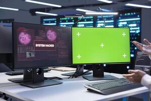Admin in server hub establishment frightened by hacker passing firewall and stealing data. Security breach notification on green screen monitor in data center making IT expert panic photo