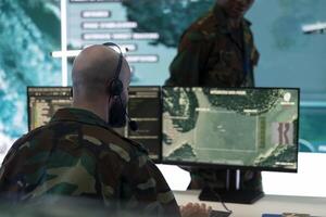 Military personnel operating on CCTV reconnaissance system in command post, gathering intelligence for an army defense operation to aid in battle. IT high tech engineer in control center. photo
