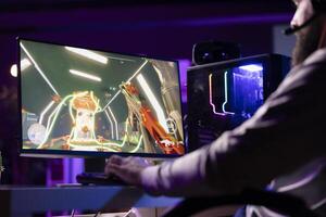 Man talks with teammates online while playing games on gaming PC, building winning strategy. Gamer battling enemies in multiplayer shooter, cooperating with people through headphones mic photo