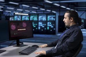 Engineer in server hub frightened by hacker passing company firewall and stealing sensitive user data. Afraid man panicking after seeing security breach notification on computer in data center photo