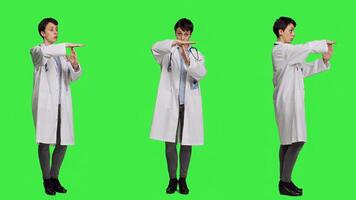 Woman physician doing timeout gesture against greenscreen backdrop, asking for a work break after multiple examinations. Doctor showing pause or stop symbol, feeling tired. Camera A. photo