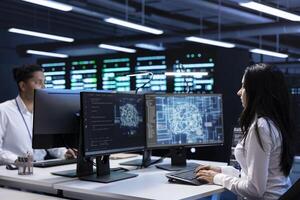 Team of specialists working on PC in data center with artificial intelligence tech to process massive datasets. Engineering colleagues solving tasks in server hub storing data used for deep learning photo