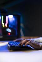 Man using keyboard to move character in game, playing with teammates online. Close up of gamer playing engaging games on gaming PC at computer desk, chilling after work photo