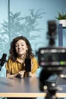 Tech guru assessing smartphone performance, feeling happy with high quality components used. Content creator shoots mobile phone review for online channel, recommending it photo