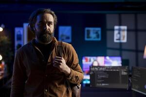 Cybersecurity expert leaves home office after finding security vulnerabilities and preventing malware infections. Developer walks away from desk after installing fortified code preventing cyberattacks photo