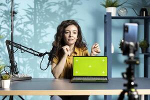 Online show host being sponsored by partnering brand to do isolated screen laptop unboxing content. Tech expert does influencer marketing, doing chroma key notebook product placement photo