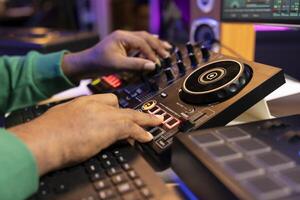 Audio technician mixing and mastering songs on a console in home studio, working with professional digital software and gear. Artist producer creating soundtracks for album. Close up. photo