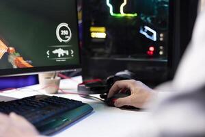 Man using gaming mouse to enjoying coop FPS videogame, battling flying robots with his online friends. Close up of gamer chatting with internet teammates while playing first person shooter game photo