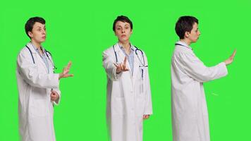 Woman health specialist showing no sign and being furious against greenscreen backdrop, expressing negativity and rage in studio. Angry physician screaming and shouting at people. Camera B. photo