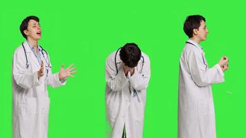Angry physician yelling at people and being aggressive in studio, getting mad and furious at something against greenscreen backdrop. Irritated annoyed medic screaming, being displeased. Camera B. photo