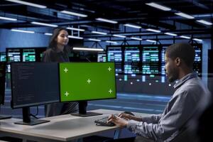 Man in data center updating systems on green screen PC to protect servers from exploitable software vulnerabilities. IT expert using mockup computer to look for errors causing servers to slow down photo