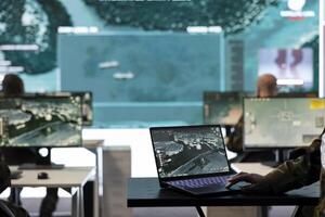Woman soldier working on military reconnaissance system in control room army base, examining crucial real time information for the combat units. Specialist collects data in power base. photo