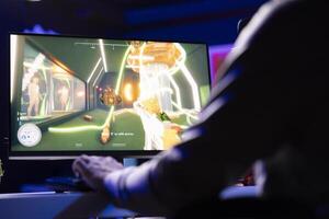 Man playing videogames, ready to start defeating enemies in first person shooter game, relaxing at home. Close up shot of pro gamer unwinding by competing in online multiplayer esports tournament photo