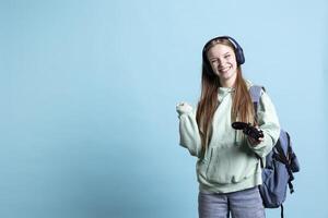 Overjoyed person playing intense gaming console game, having fun, isolated over studio background. Joyous woman pleased after being victorious in videogame, defeating all enemies using gamepad photo