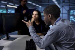 Multiethnic team reconfiguring server farm to optimize it for data processing requirements of customers. Coworkers collaborating to ensure data center equipment operates efficiently photo