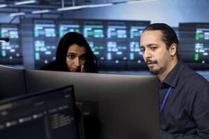 Engineers reconfiguring server farm to optimize it for data processing requirements of customers. IT professionals ensuring that data center equipment operates efficiently photo