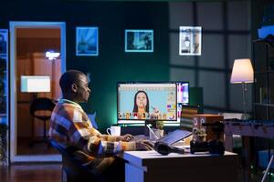 African american graphic designer working on photo retouching project on dual monitors in a modern office setting at his home. Man showcasing creativity in digital editing software.